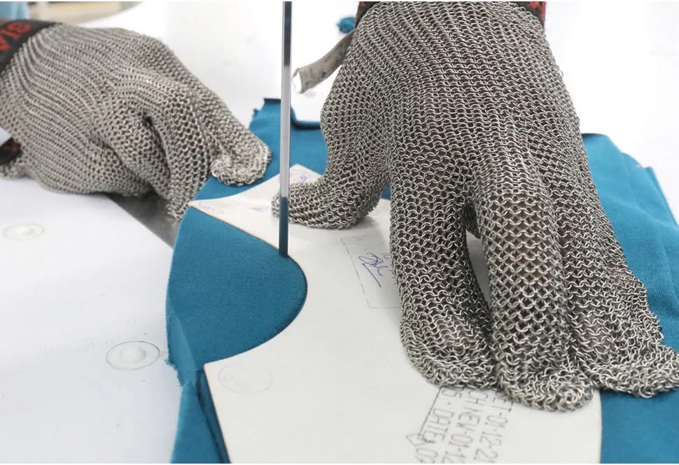 Protected hands guiding fabric during precision cutting